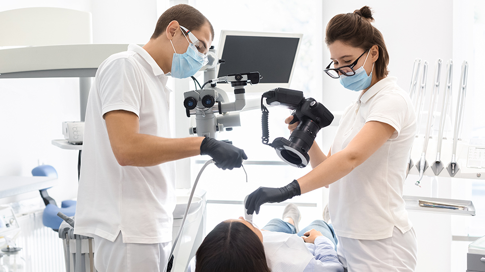 Dental assistant and Dentist taking photo of patient's teeth