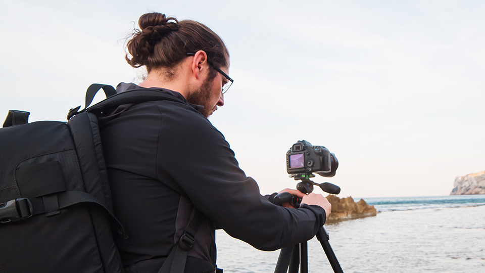 Man adjusting tripod